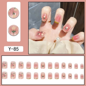 Pink gradient press-on nails with tulip floral patterns and green edge details
