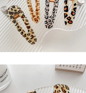 Detail shot of leopard print hair clips and acetate claw clips on a glass tray