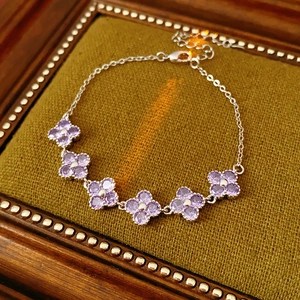 Detail of silver clover bracelet with purple cubic zirconia on vintage jewelry box