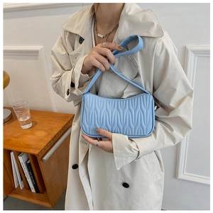 Detail shot of the textured blue PU leather surface and handle on this stylish handbag