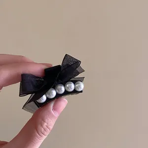 Detailed shot of a French black mesh bow hair claw clip with elegant pearls decoration