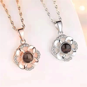 Detail of rose gold and silver flower necklaces with projection stone and zircon accents