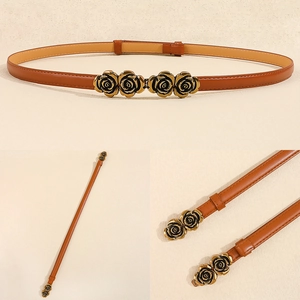 Macro detail of brown leather belt with gold rose buckle and vintage metallic accents