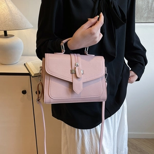 Pink minimalist PU leather handbag with detachable shoulder strap shown in a home setting