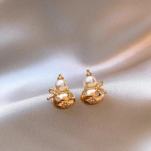 Detailed view of gourd-shaped gold earrings with pearls and star-set diamonds