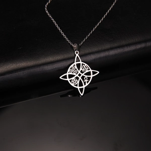 Macro shot of silver stainless steel Celtic cross star pendant with occult mystic symbols