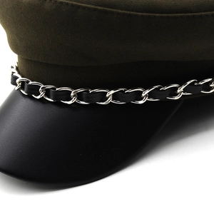 Detail of olive green canvas cap featuring a silver metal chain and black leather brim