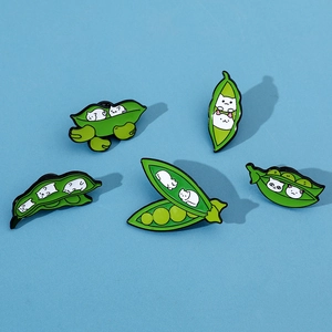 Macro view of five creative cat pea pod enamel pins on a vibrant blue background