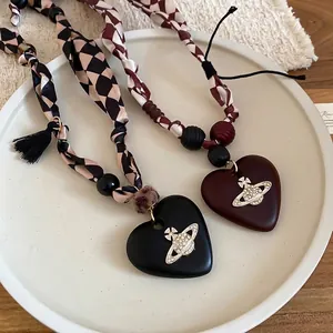 Vintage wood bead heart pendant necklace with checkered ribbon and rhinestone orb detail