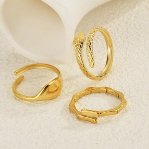 Three-piece set of gold stainless steel rings featuring snake, bamboo, and smooth designs