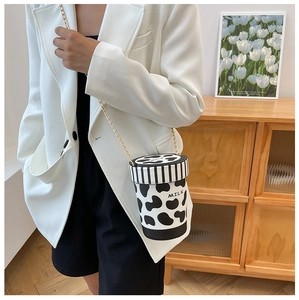 Detailed close-up of cow print milk cup bucket bag with golden chain and MILK text