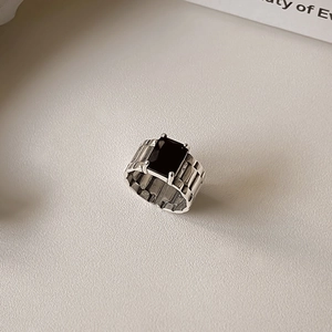 Macro detail of 925 silver ring featuring a large black gemstone and ribbed band