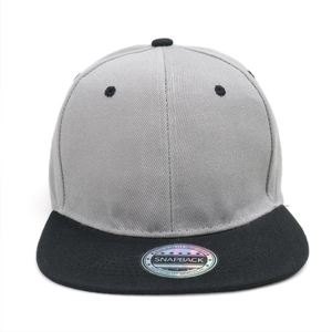 Detail of grey and black snapback hat with holographic silver quality sticker on brim