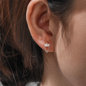 Macro view of sterling silver crown stud earring with zircon tassels worn on ear