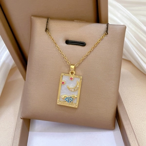 Macro detail of golden tarot moon necklace with colorful gemstones on silk