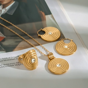 Detail view of a gold jewelry set with concentric circles and crystals on a magazine