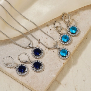Retro round jewelry set with blue gemstone necklace and earrings on silk background