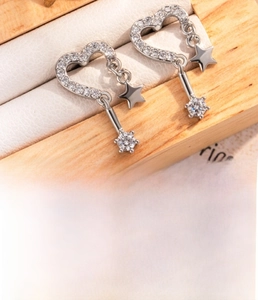Macro detail of silver heart stud earrings with cubic zirconia and screw back