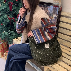 Detailed view of the dark green plush fleece tote bag featuring a white square woven label