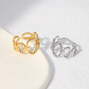 Close-up of gold and silver chain link rings on a minimalist textured surface