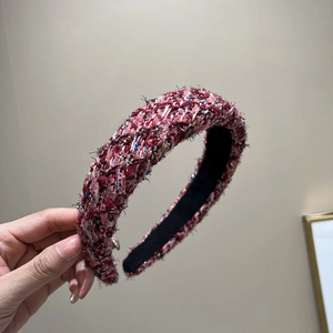Macro detail of red and blue tweed headband with woven texture and fringe edges