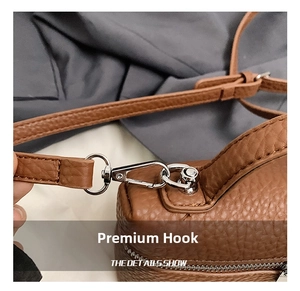 Detail of silver alloy hook and brown lychee grain leather texture on women's box handbag