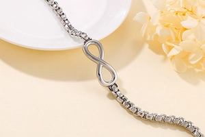 Vue détaillée d'un bracelet infini argenté sur une assiette avec des fleurs séchées