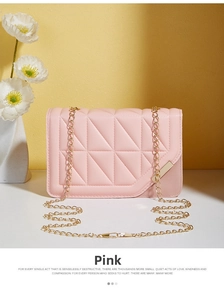 Detail of pink quilted shoulder bag with golden chain strap and metallic trim finish