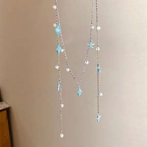 Détail du collier argenté multicouche avec étoiles de mer bleues, coquillages et perles