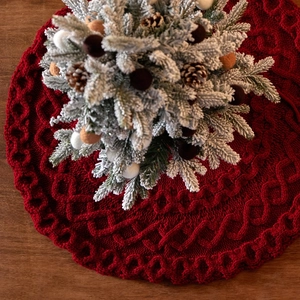 Tapis de sapin de Noël rond en tricot rouge avec des motifs torsadés élégants