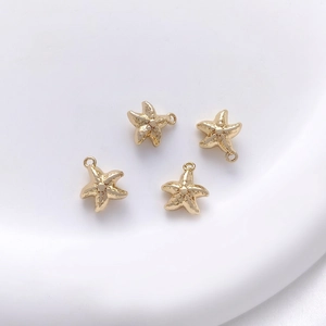 Detailed view of four 14K gold plated starfish pendants with top loops for DIY jewelry