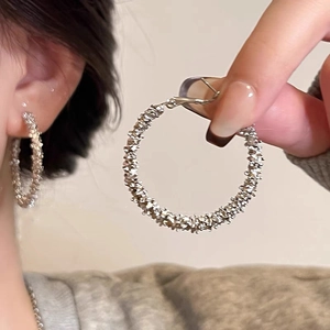 Boucles d'oreilles créoles argentées avec texture tissée de style minimaliste