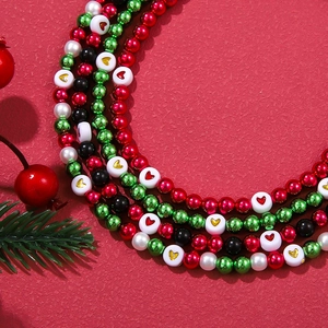 Close-up of festive Christmas beaded necklaces with heart motifs and holiday greenery decor