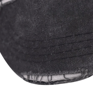 Close-up of distressed brim details on a black washed cotton baseball cap with stitching