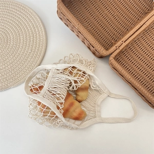 Vue détaillée du sac en filet macramé beige montrant la texture tissée en coton