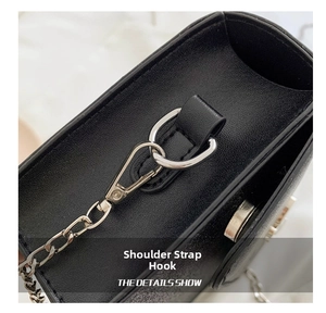 Close-up of silver lobster clasp and strap connection on black lychee grain bag
