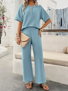 Detail view of a blue short-sleeve knit top and wide-leg pants lounge set on a model