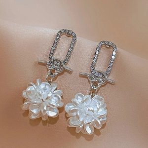 Detailed view of silver flower earrings with crystals and white acrylic floral petals