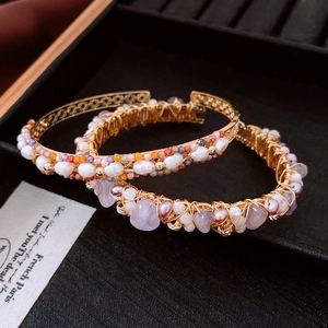 Detail of 18K gold plated bangle with wrapped amethyst stones and white pearls