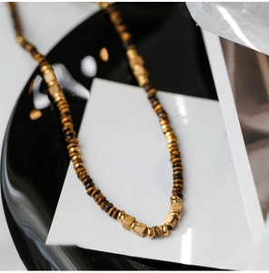 Detail of square tiger eye stone beads and gold metal spacers on a vintage necklace