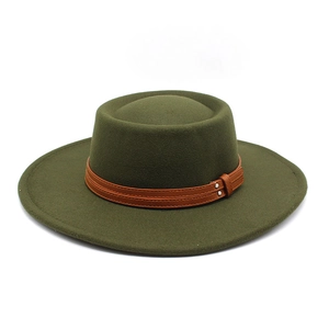 Detail of dark green wool felt boater hat with brown leather strap and metal rivets