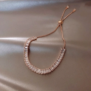 Roségold Armband mit quadratischen Zirkonia auf luxuriösem Champagner Seidenhintergrund