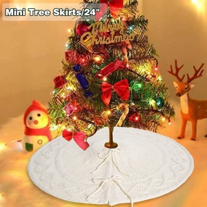 Detail of white 24-inch knit Christmas tree skirt with textured diamond pattern and bow ties