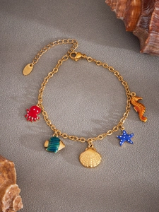 Detail eines goldenen Meeres-Armbands mit bunten Emaille-Anhängern wie Krake und Fisch