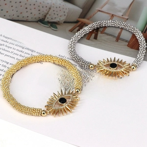 Close-up of gold and silver beaded evil eye bracelets with crystal sunburst details