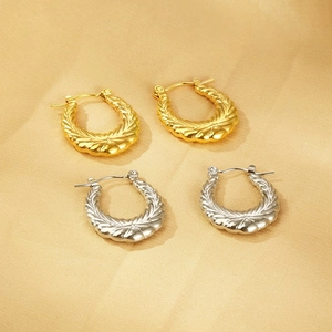 Detail of 18k gold and silver U-shaped earrings with vintage rippled spiral texture