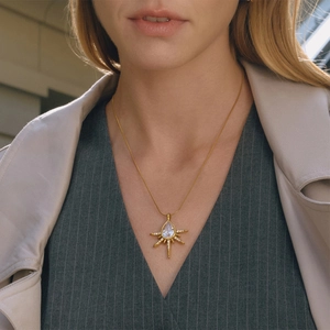 Gros plan d'un collier doré en étoile avec pendentif en zircone en forme de poire