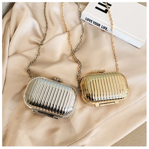 Detail of metallic gold and silver mini hardshell crossbody bags with vertical stripes