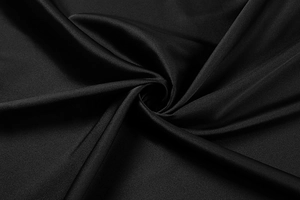 Gros plan d'un tissu en satin noir élégant avec un drapé en spirale sophistiqué