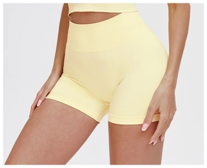 Detail view of seamless high-waisted yoga shorts with supportive ribbed waistband in yellow
